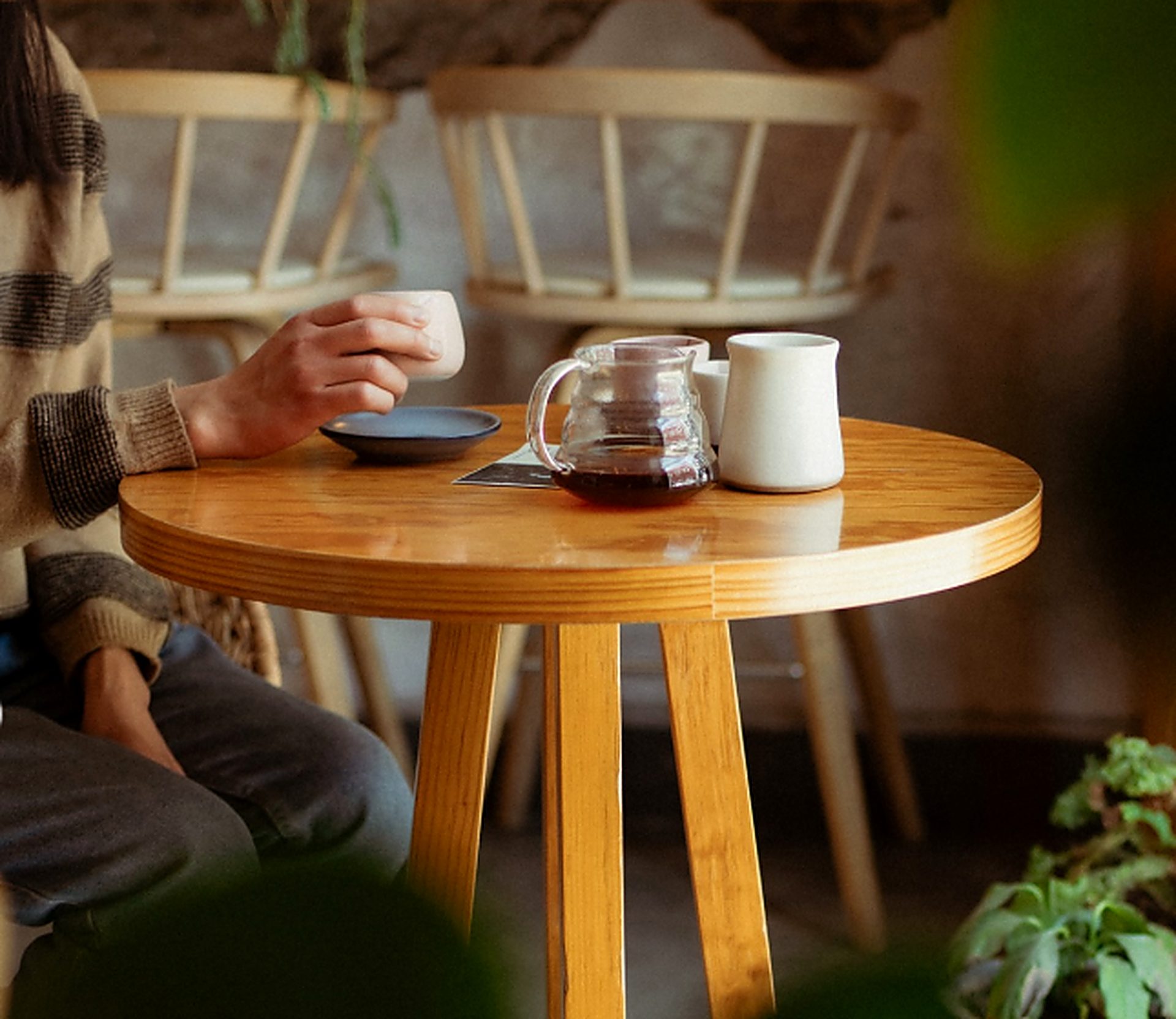 Cliente disfrutando un café de filtro sobre una mesa de madera en Clemente Café