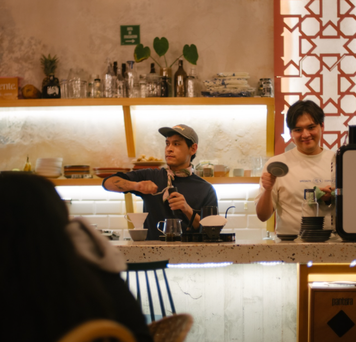 Celosía de terracota sobre la barra de Clemente mientras los baristas preparan café